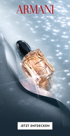 Armani Si Parfümflakon mit pfirsichfarbener Flüssigkeit und elegantem schwarzem Verschluss. Der Flakon liegt auf einer schimmernden silbernen Oberfläche mit sanften Lichtreflexen. Oben steht in großen roten Buchstaben ‚ARMANI‘